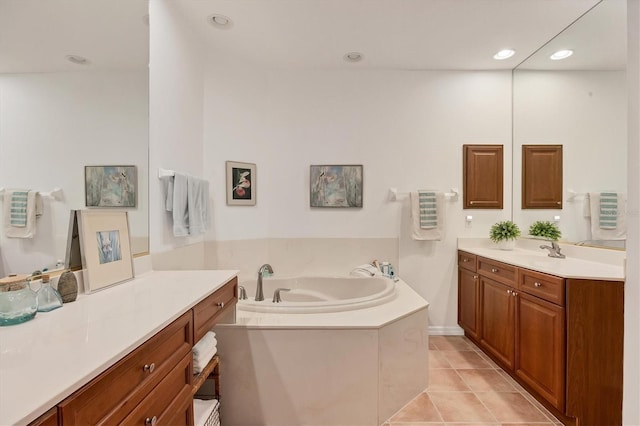 bathroom featuring a relaxing tiled tub, tile patterned flooring, and vanity