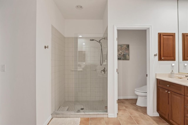 bathroom with tile patterned floors, a tile shower, vanity, and toilet