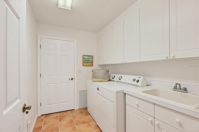 washroom featuring sink, washer and clothes dryer, light tile patterned floors, and cabinets