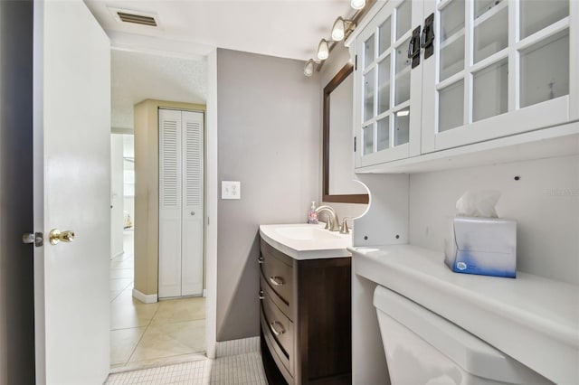 bathroom featuring vanity, tile patterned flooring, and toilet