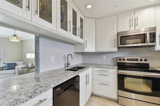 kitchen featuring light tile patterned flooring, appliances with stainless steel finishes, light stone countertops, sink, and white cabinets