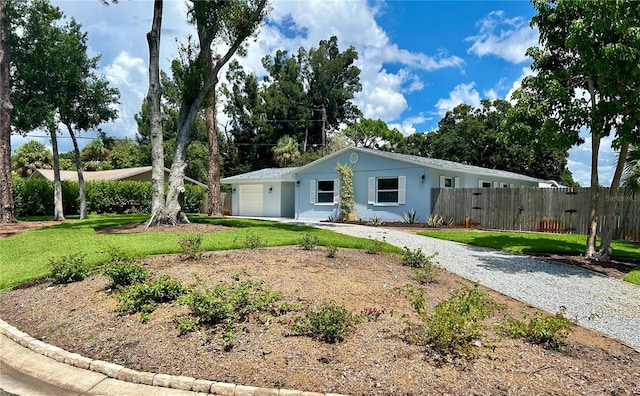 ranch-style home with a garage and a front lawn