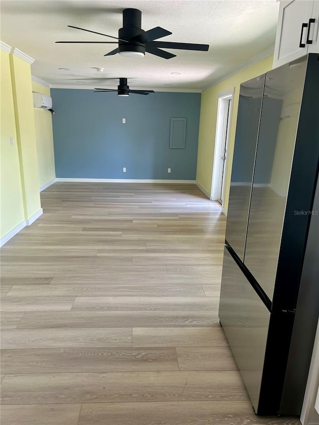 spare room featuring ornamental molding, light hardwood / wood-style flooring, a textured ceiling, and ceiling fan