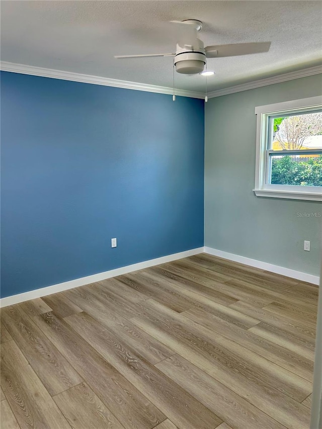 empty room featuring a textured ceiling, hardwood / wood-style floors, ceiling fan, and crown molding