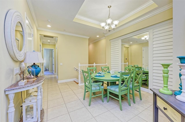 tiled dining space with a notable chandelier, ornamental molding, and a raised ceiling