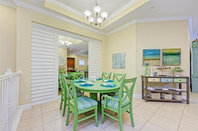 dining area featuring a notable chandelier, ornamental molding, light tile patterned flooring, and a raised ceiling