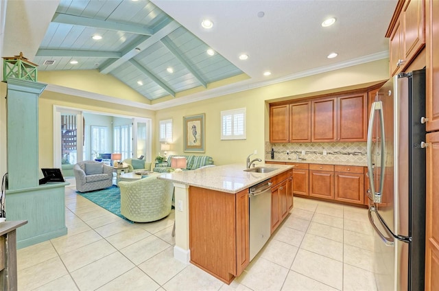 kitchen with vaulted ceiling with beams, stainless steel appliances, a center island with sink, sink, and light stone countertops