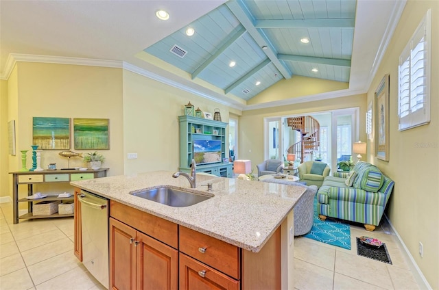 kitchen featuring stainless steel dishwasher, light stone countertops, sink, and an island with sink