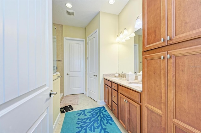 bathroom featuring vanity, a shower, and tile patterned floors