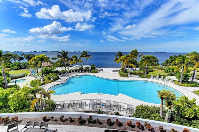 view of swimming pool featuring a water view and a patio