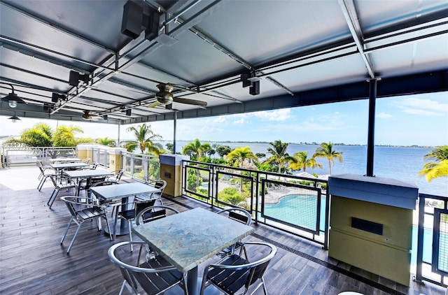 wooden deck with a water view and ceiling fan