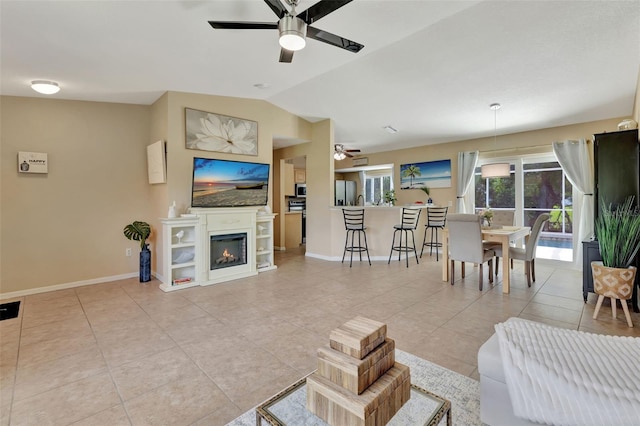 living room with ceiling fan, light tile patterned floors, and lofted ceiling