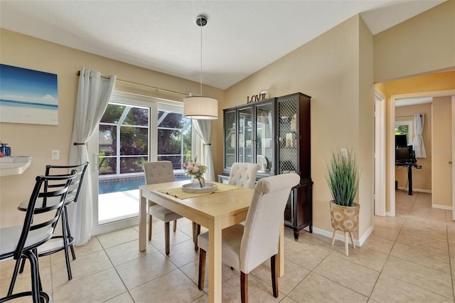 tiled dining space featuring lofted ceiling