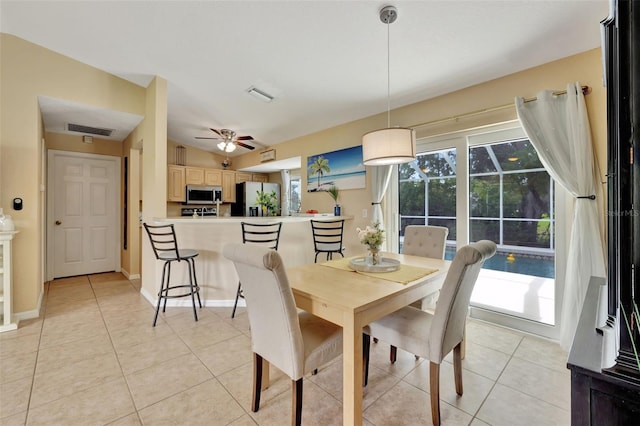 tiled dining space with ceiling fan and vaulted ceiling