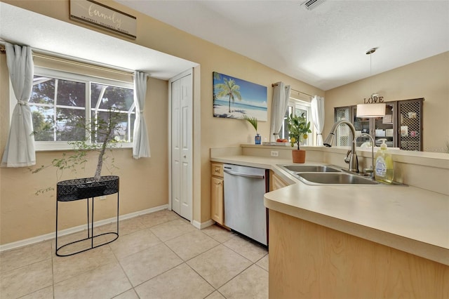 kitchen with lofted ceiling, sink, stainless steel dishwasher, light tile patterned flooring, and pendant lighting