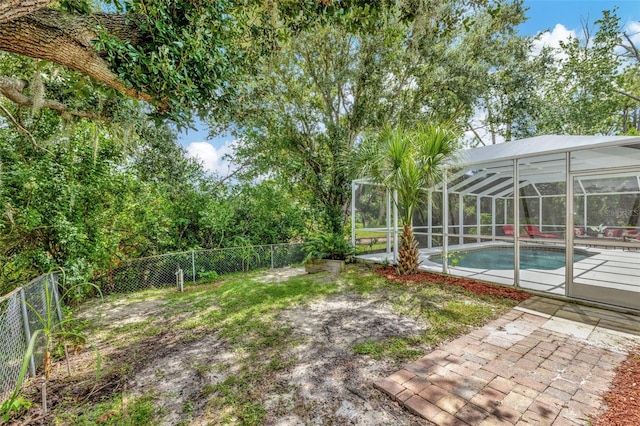 view of yard with a lanai, a fenced in pool, and a patio area