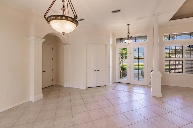 entrance foyer with decorative columns, french doors, and light tile patterned floors