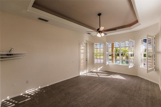 carpeted spare room with a tray ceiling, ceiling fan, and ornamental molding