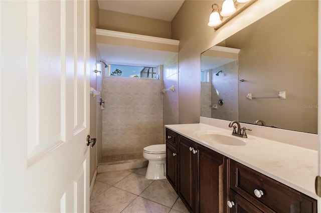 bathroom featuring tile patterned floors, vanity, toilet, and tiled shower