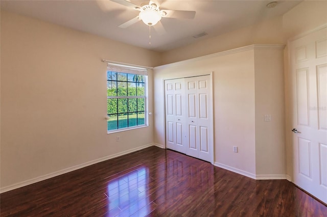 unfurnished bedroom featuring ceiling fan, dark hardwood / wood-style floors, and a closet