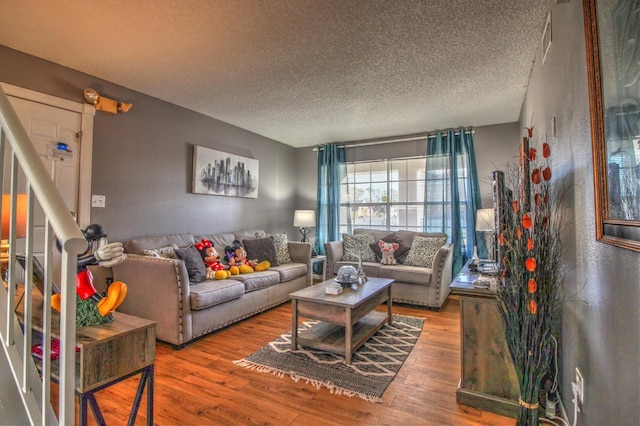 living room featuring wood-type flooring and a textured ceiling