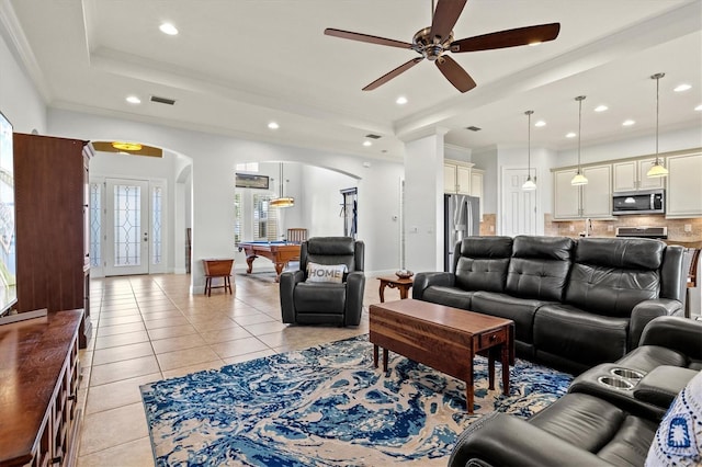 tiled living room with a raised ceiling, ceiling fan, crown molding, and billiards