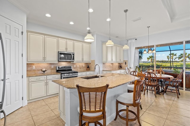 kitchen with light stone countertops, stainless steel appliances, sink, light tile patterned floors, and decorative light fixtures