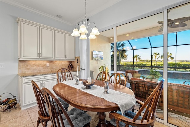 tiled dining space featuring ceiling fan with notable chandelier and ornamental molding