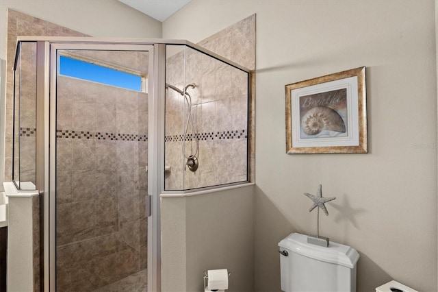 bathroom with a shower with door and toilet