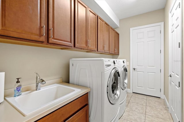 washroom with washer and clothes dryer, sink, light tile patterned flooring, and cabinets