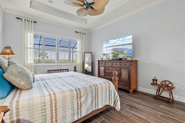 bedroom featuring dark hardwood / wood-style flooring, a raised ceiling, ceiling fan, and crown molding