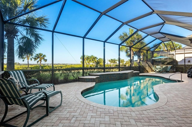 view of pool with a patio and glass enclosure