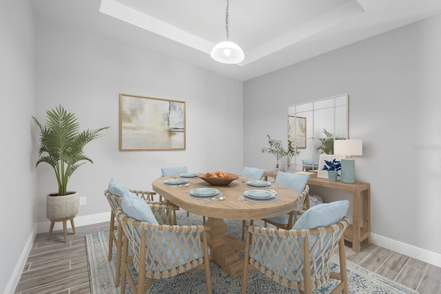 dining room featuring hardwood / wood-style floors and a tray ceiling