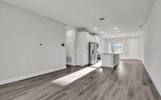 interior space with sink, a center island, dark wood-type flooring, white cabinets, and appliances with stainless steel finishes