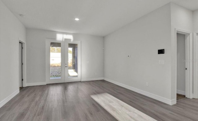 empty room with hardwood / wood-style floors and french doors