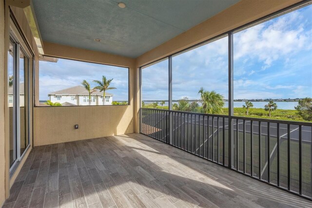 unfurnished sunroom with a water view and a healthy amount of sunlight