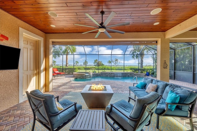 view of patio with an in ground hot tub, pool water feature, an outdoor living space with a fire pit, and a lanai