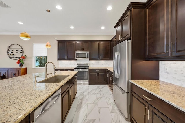 kitchen with sink, hanging light fixtures, stainless steel appliances, light stone counters, and ornamental molding