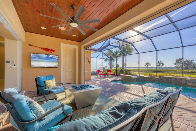 view of patio with an in ground hot tub, an outdoor living space with a fire pit, and glass enclosure