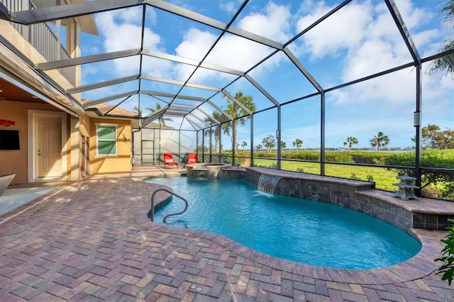 view of pool featuring an in ground hot tub, a lanai, pool water feature, and a patio area