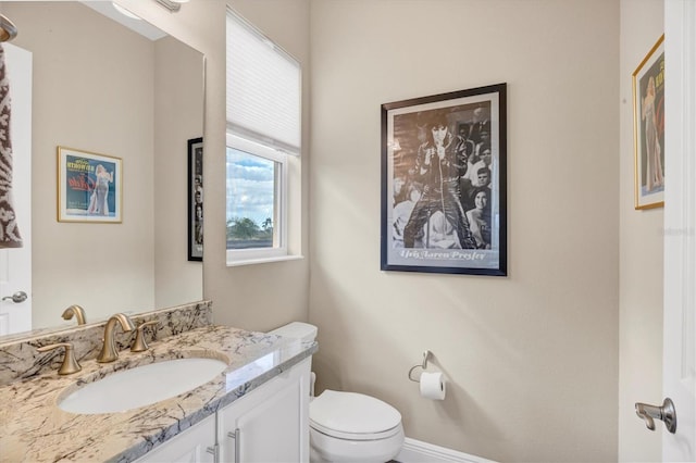 bathroom featuring vanity, a wealth of natural light, and toilet