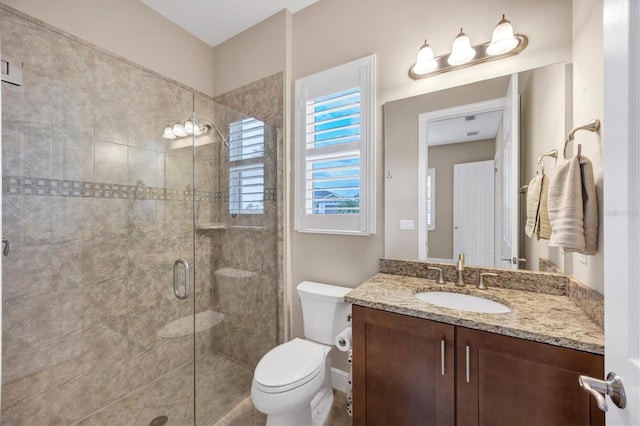 bathroom with vanity, toilet, and a shower with door