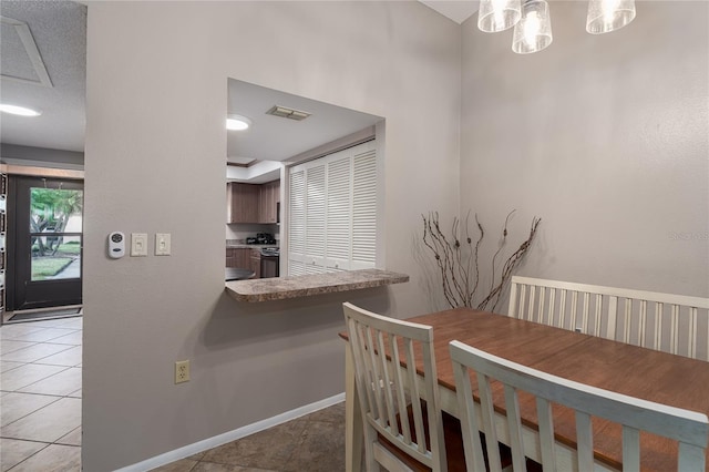 tiled dining space with a textured ceiling