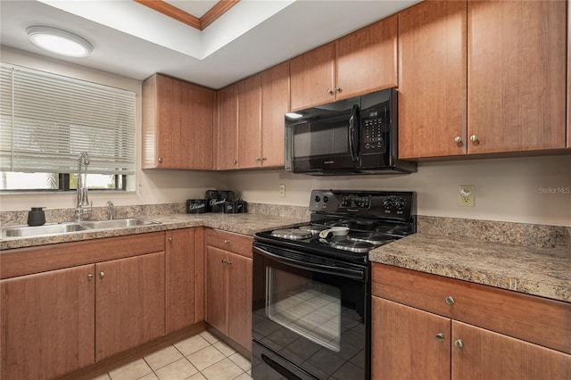 kitchen featuring light tile patterned flooring, sink, black appliances, a raised ceiling, and crown molding