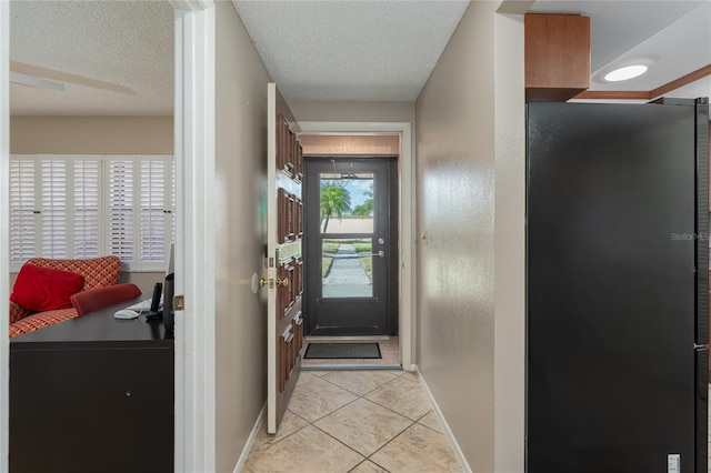 doorway with light tile patterned floors and a textured ceiling