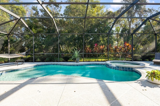 view of swimming pool featuring a patio, a lanai, and an in ground hot tub