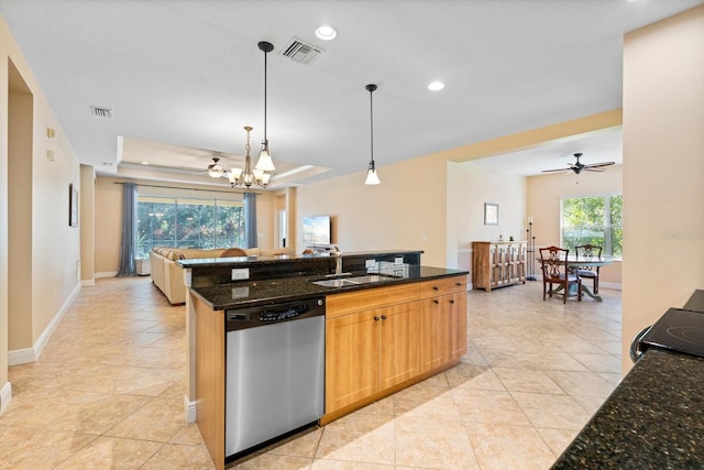 kitchen featuring dishwasher, a tray ceiling, dark stone countertops, sink, and pendant lighting