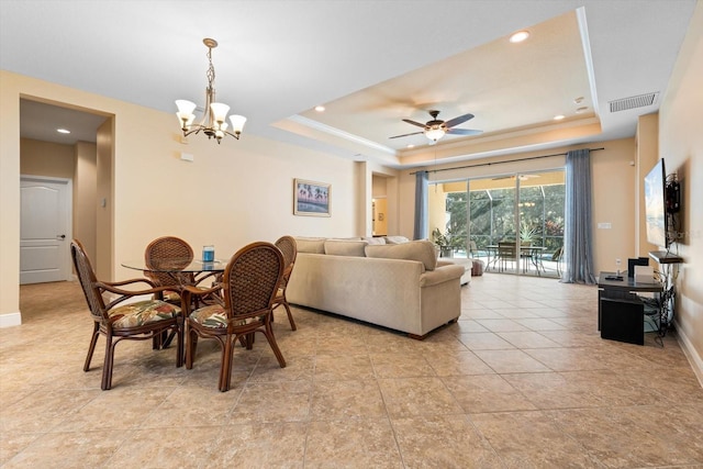 dining area featuring crown molding, a tray ceiling, and ceiling fan with notable chandelier