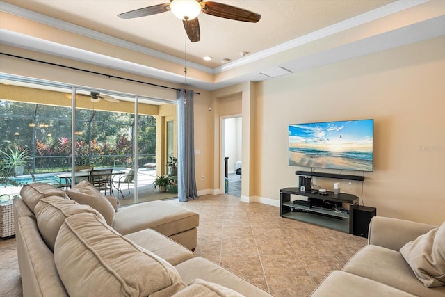 tiled living room featuring ornamental molding, a tray ceiling, and ceiling fan