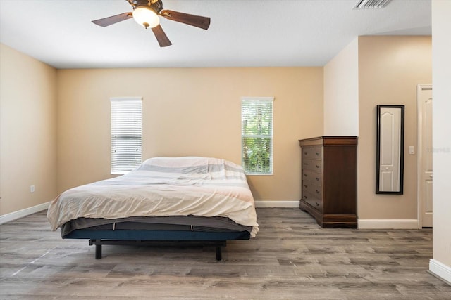 bedroom featuring light hardwood / wood-style flooring, multiple windows, and ceiling fan